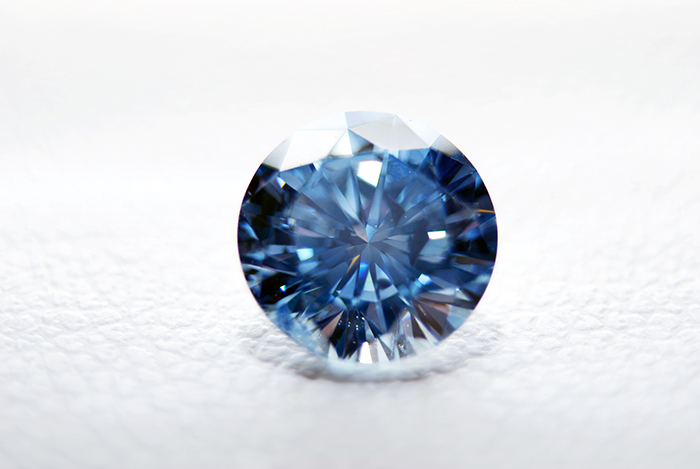 Bild zeigt einen blauen Erinnerungsdiamanten auf weißem Leder