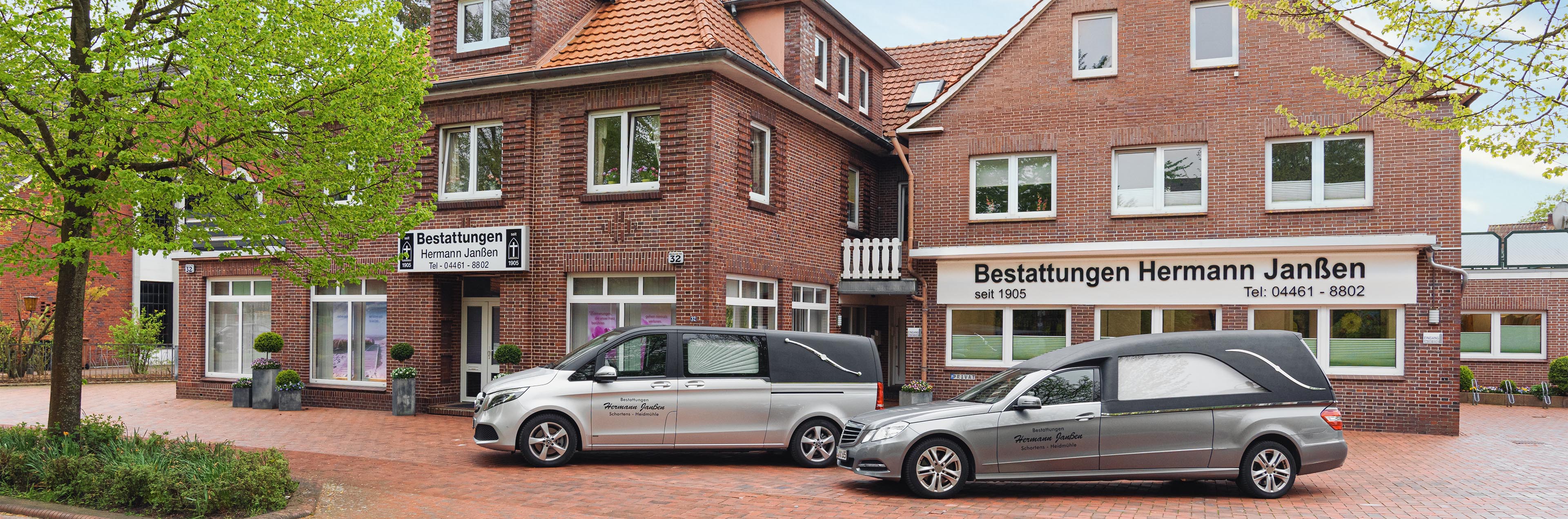 Außenansicht des Bestattungsinstitut Hermann Janßen mit Firmengebäude und zwei Bestattungsfahrzeugen